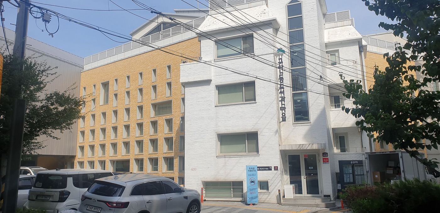 구산동도서관마을 건물이에요. 벽에 도서관 이름이 세로로 쓰여 있어요