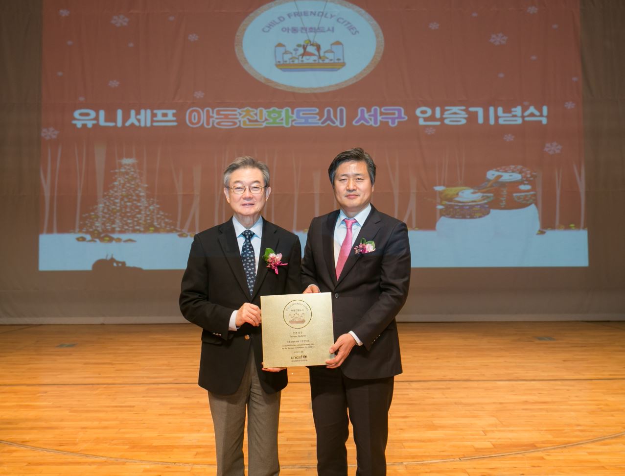2017년 12월, 인천 서구가 유니세프 아동친화도시 인증을 받고 연 기념식이에요. 유니세프한국위원회 사무총장(왼쪽)과 서구청장(오른쪽)이 인증패를 들고 있어요.