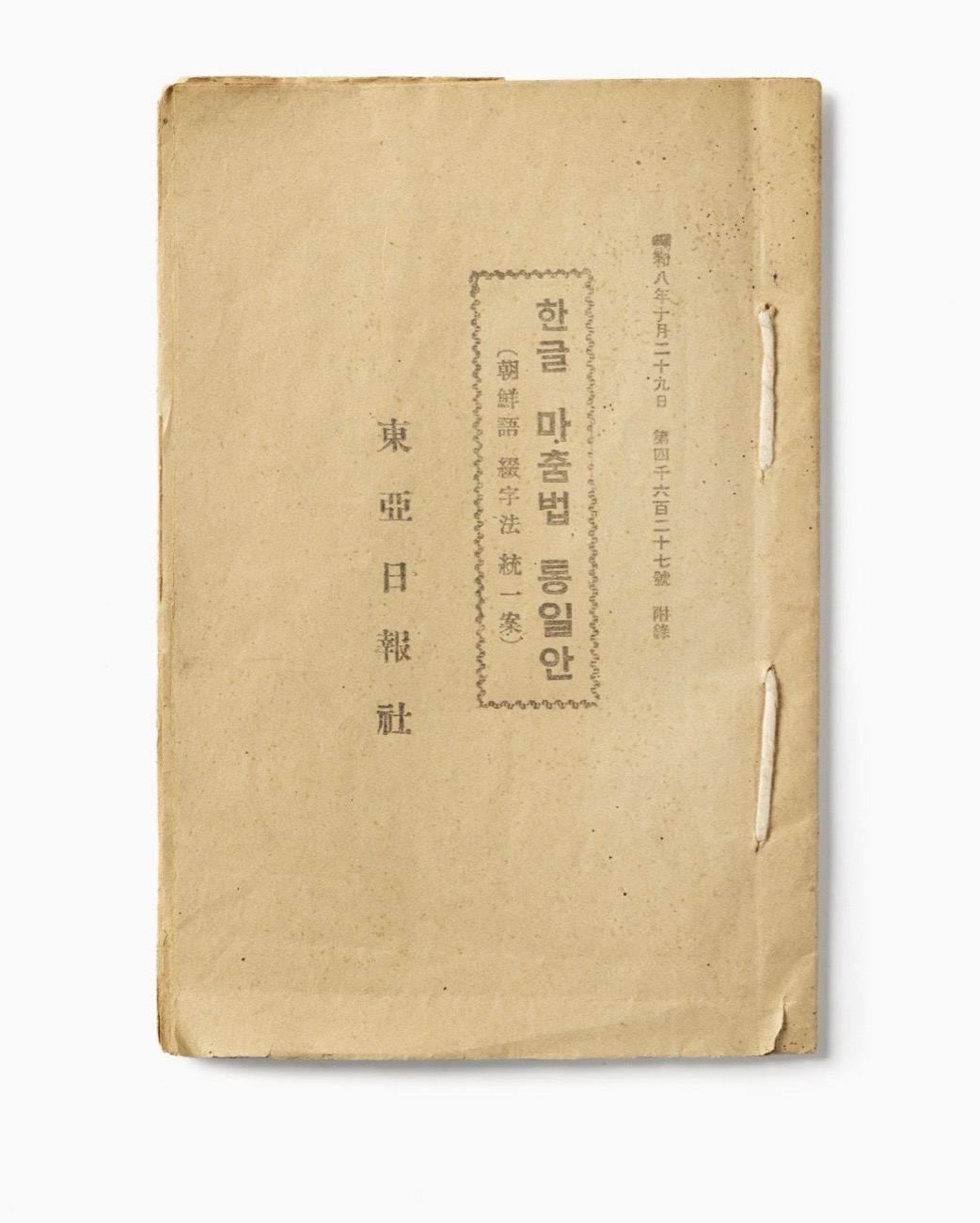 1933년에 나온 「한글 마춤법 통일안」 표지예요. 왼쪽에 가장 큰 글씨로 「東亞日報社(동아일보사)」라고 세로로 적혀 있어요. 가운데 네모 테두리 안에 「한글 마춤법 통일안」이라 적고, 그 왼쪽에 작게 「朝鮮語綴字法統一案」이라 붙였어요. 오른쪽 끝에는 날짜와 함께 「附錄(부록)」이라는 글자가 보여요. 지금 맞춤법과 달리 「마춤법」으로 적혀 있어요.
